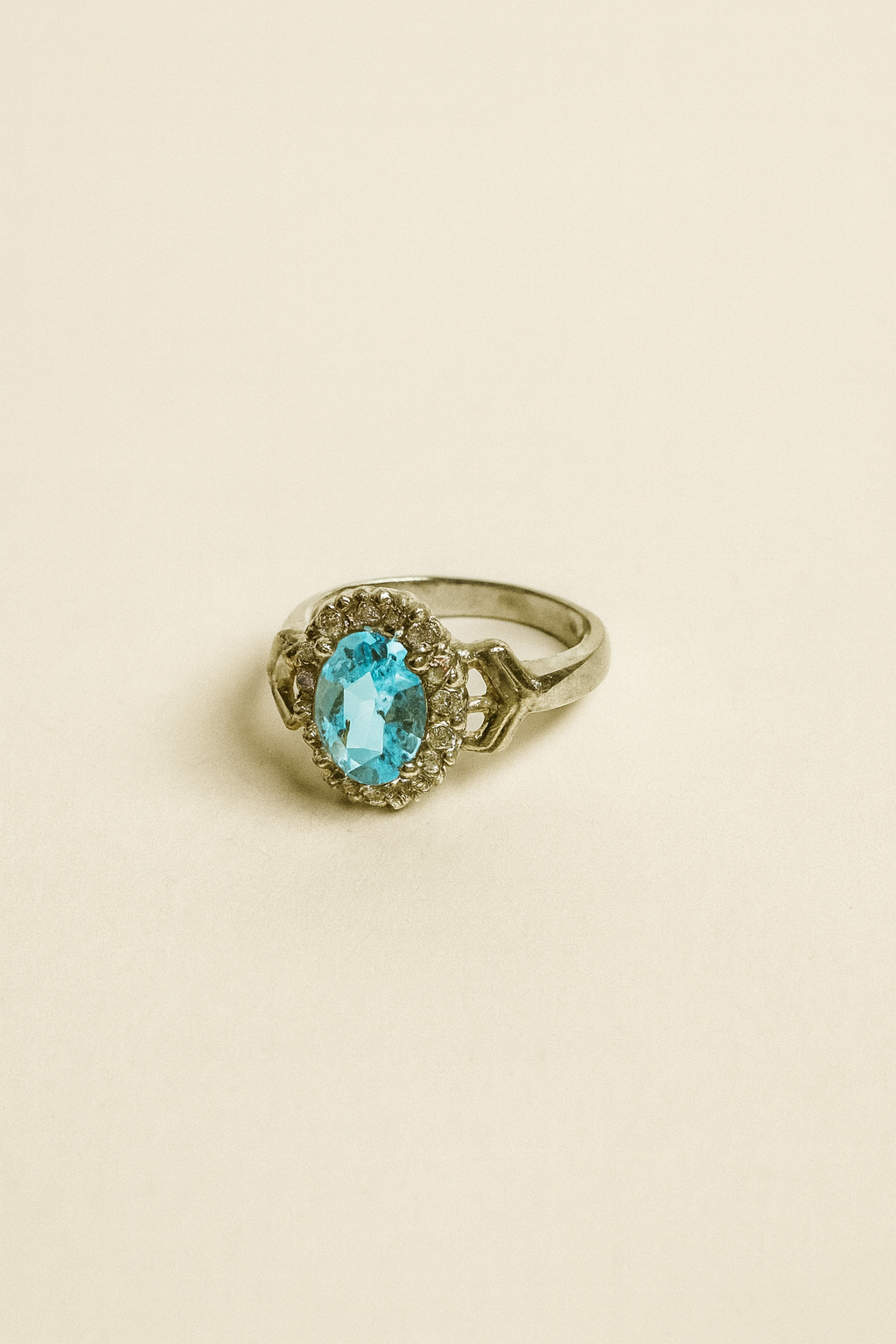 Gold ring with a blue gemstone on a beige background